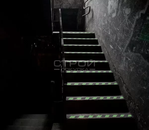 Клеющаяся светящаяся лента на темной лестнице в подвале.