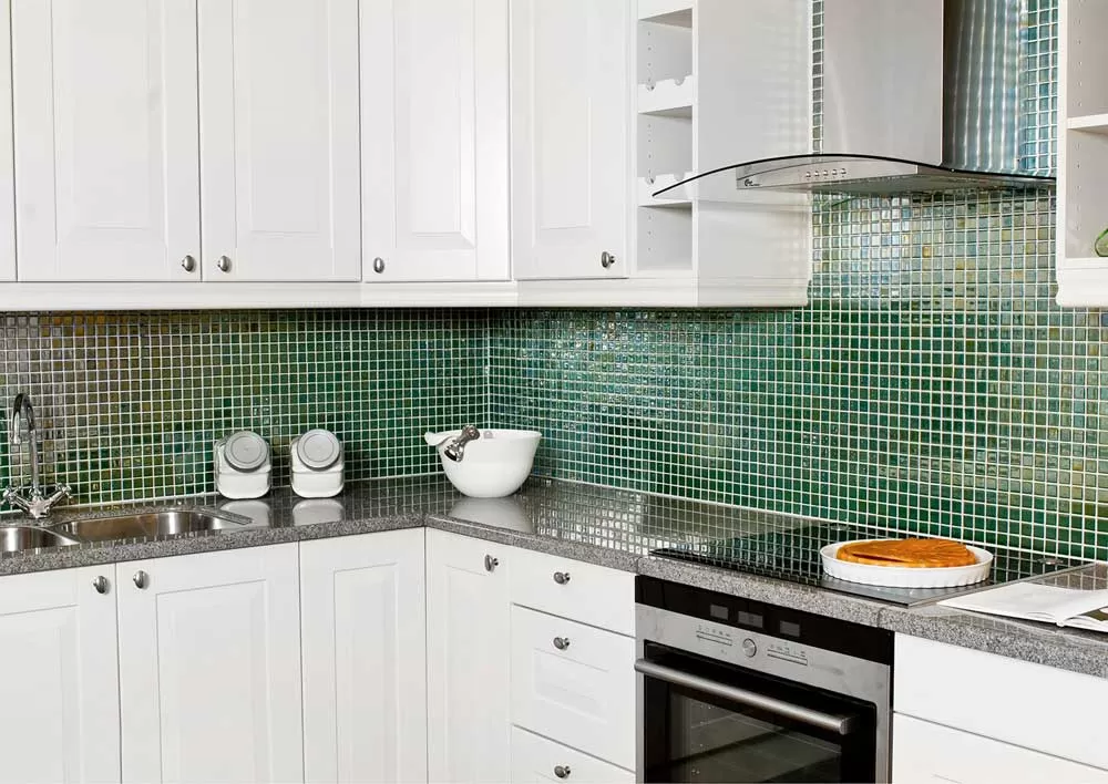 Глянцевая мозаика Esmeralda Metal зеленого цвета использована для кухонного фартука.