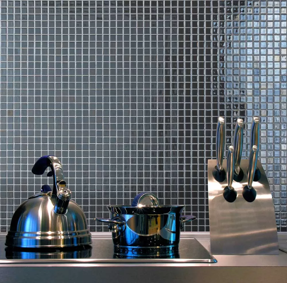 Интерьер рабочей зоны на кухне с глянцевой мозаикой Inox Metal серого цвета производства Ezarri.